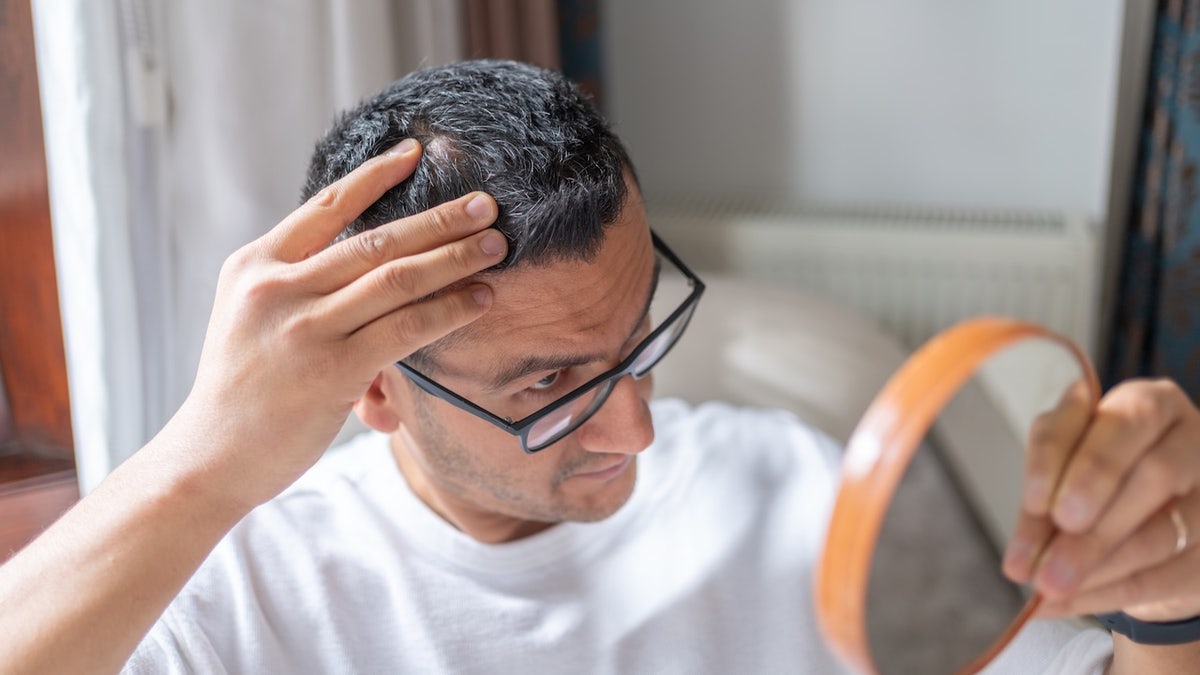 man-looking-at-hair-in-mirror